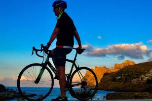 a man standing with a bike on the beach at Puerto Pollensa peaceful apartment, mountain views in Port de Pollensa +7 photos
