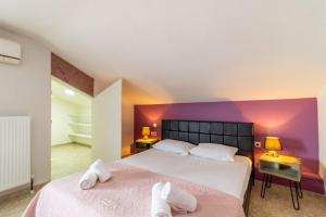 two beds in a room with a purple wall at Dimitra Boutique Apartments 1 in Keramoti