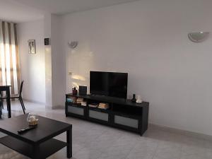 a living room with a flat screen tv on a wall at Suite Yumbo in Maspalomas