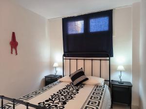a bedroom with a bed with a black headboard and a window at Suite Yumbo in Maspalomas +23 photos