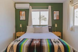 a bedroom with a large bed and two windows at Grand Desert Oasis - SPA - A Location - JT Park in Joshua Tree