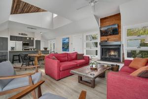 a living room with red furniture and a fireplace at Poole's Cove - Waterfront; Main Street! in Deep Hole