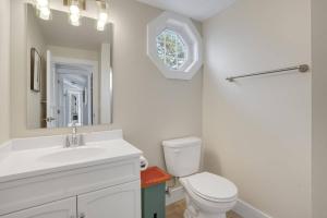 a bathroom with a sink and a toilet and a mirror at Poole's Cove - Waterfront; Main Street! in Deep Hole +60 photos