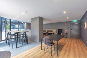 an open living room with tables and chairs at Luxurious Cozy 1-Bed FREE Carpark Gym Pool & Spa in Belconnen