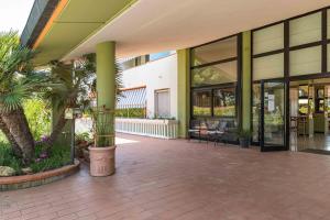 eine Lobby eines Gebäudes mit Palmen und Pflanzen in der Unterkunft Hotel Riva Etrusca in Marina di Bibbona