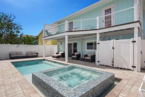 a swimming pool in front of a house at Lazy Lobster by Sun Palace Vacations in Fort Myers Beach
