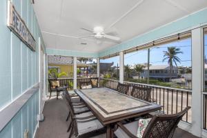 a table and chairs on a balcony with a ceiling fan at Lazy Lobster by Sun Palace Vacations in Fort Myers Beach