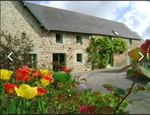 a stone house with flowers in front of it at Au Mont De La Quintine # Piscine & Jacuzzi # in Saint-Quentin-sur-le-Homme