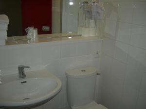 a bathroom with a sink and a toilet and a mirror at Hôtel du Val de Seine in Mantes-la-Jolie +19 photos