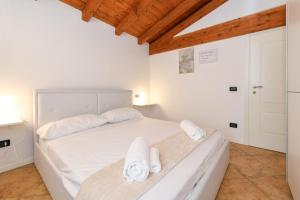 1 dormitorio con 1 cama con sábanas blancas y toallas en Wendy Apartment- Twobedroom & Pool & ParkPrivateFree & Sports, en Desenzano del Garda 31 fotos más