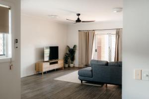 a living room with a couch and a tv at Unit 4, Rocky CBD in Rockhampton