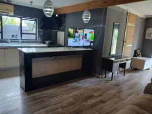 a living room with a flat screen tv on a wall at Urban Villa 25 in Gaborone