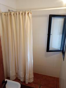 a bathroom with a shower curtain and a window at La escondida las siringuillas in Tafí del Valle +37 photos