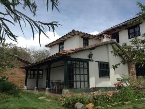 a white house with black windows at DOFA Hosteria in Villa de Leyva