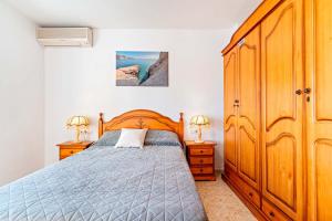 a bedroom with a wooden bed and two night stands at Apartamento con Vista al Mar in Roquetas de Mar +23 photos