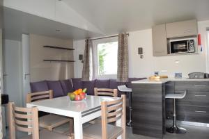 Caravana con cocina y comedor con mesa y sillas en Mobile home - Bonne Anse La Palmyre - 8 pers, en Les Mathes