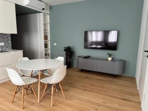 a dining room with a white table and white chairs at Affittacamere38B in Pordenone