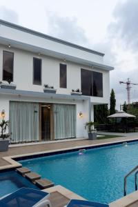 una villa con piscina frente a una casa en De Cove, en Ogbojo