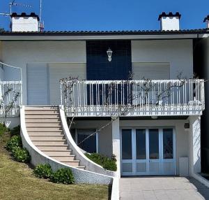 een huis met een trap en een balkon bij Casa do Farol in Viana do Castelo