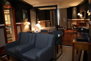 a hotel room with a bed and two chairs at Hotel 1898 in Barcelona