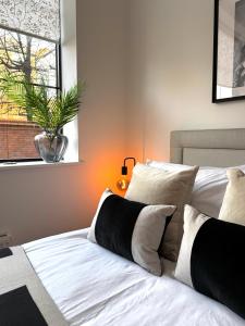 1 cama con almohadas blancas y negras y ventana en Chester's - Central Chester Stays - 2 Cuppin Street - 2 Minute Walk From Shops, en Chester