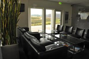 a living room with black leather chairs and a table at Sand Golf Club in Bankeryd
