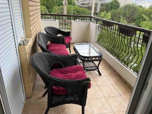 tres sillas y una mesa en un balcón en M`s Luxury Apartments, en Skopje