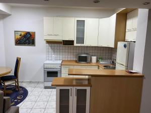 Una cocina con gabinetes blancos y encimera. en M`s Luxury Apartments, en Skopje 5 fotos más