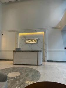 ドバイにあるSunlit serenity Studio Azizi Rivieraの壁に看板のあるテーブルが備わる部屋 +21枚の写真