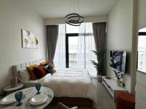 ドバイにあるSunlit serenity Studio Azizi Rivieraのベッドと大きな窓のある寝室