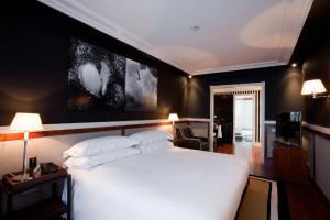 a bedroom with a white bed and a black wall at Hotel 1898 in Barcelona