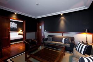 a living room with a couch and a bed at Hotel 1898 in Barcelona