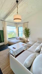 a living room with white furniture and a large window at The Cliffs - Vue de Pantin in Valdoviño