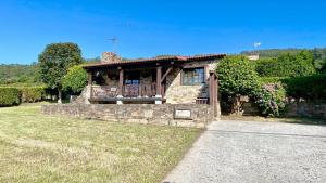 a stone house with a porch and a balcony at The Cliffs - Vue de Pantin in Valdoviño