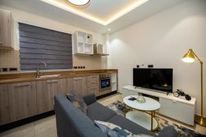 Una sala de estar con un sofá azul y una cocina. en Luxury Studio at Park, en Accra