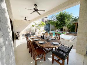 Luxury House Tomanoa - 10pers - 4rooms - Pool - HotJacuzzi - Speed Wifi -waterfall في تولوم: غرفة طعام مع طاولة وكراسي خشبية +54 صورة