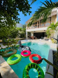 Luxury House Tomanoa - 10pers - 4rooms - Pool - HotJacuzzi - Speed Wifi -waterfall في تولوم: حمام سباحة مع نزلات ملونة في أحد المنتجعات