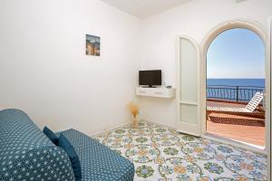 a living room with a blue couch and a balcony at House Dream on the sea in Massa Lubrense