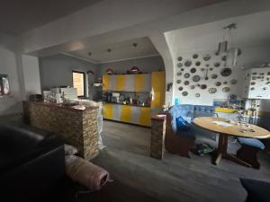 ein Wohnzimmer mit einem Tisch und einer Küche in der Unterkunft Casuta de vis in Bukarest