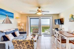 Una sala de estar con un sofá y una mesa y un comedor. en Walk to Ocean Family Retreat in Ormond Beach!, en Ormond Beach