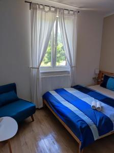 a bedroom with a blue bed and a window at Lávka 222 in Chocerady