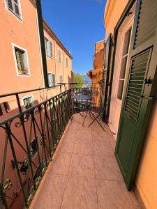 balkon z zielonymi drzwiami i stołem w obiekcie Appartement T2 Vieux Port d'Ajaccio w Ajaccio