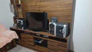 a television and speakers on a wooden entertainment center at Linda e aconchegante casa in Toledo