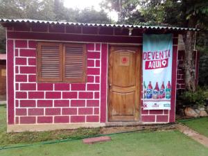 a small pink house with a door and a sign at cabaña la soberbia in Las Pozas