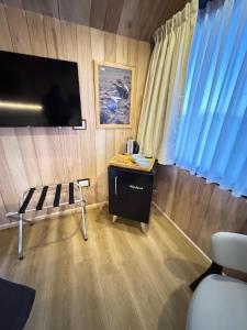 Habitación con TV y mesa con silla. en Cauquenes Suites, en Río Gallegos