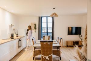 a woman standing in a kitchen with a table at L'Atelier du Pont in Guichen