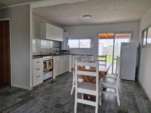 una cucina con tavolo, frigorifero, tavolo e sedie di Lugar de Descanso Azul ad Azul