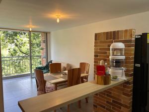 Una cocina con una mesa y una pared de ladrillos. en Apartamento Portanova, vista al bosque, en Piedecuesta