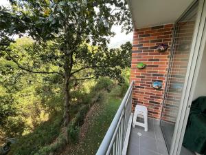 una silla blanca sentada en el balcón de una casa en Apartamento Portanova, vista al bosque, en Piedecuesta