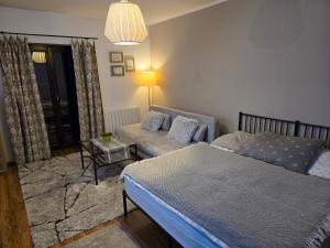 a bedroom with a bed and a couch and a table at Apartment Barbora 2 in Ružomberok